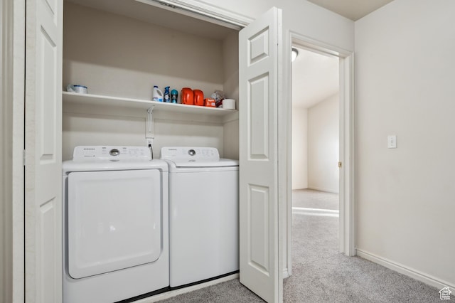 laundry area with washer and clothes dryer and light colored carpet