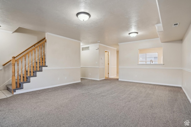 carpeted spare room featuring ornamental molding and a textured ceiling