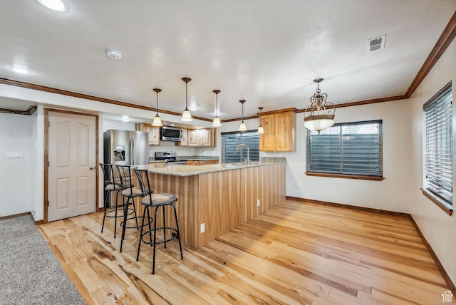 12159 S Swensen Cir, Riverton, UT 84096 - kitchen with appliances with stainless steel finishes, light wood finished floors, a peninsula, crown molding, and baseboards