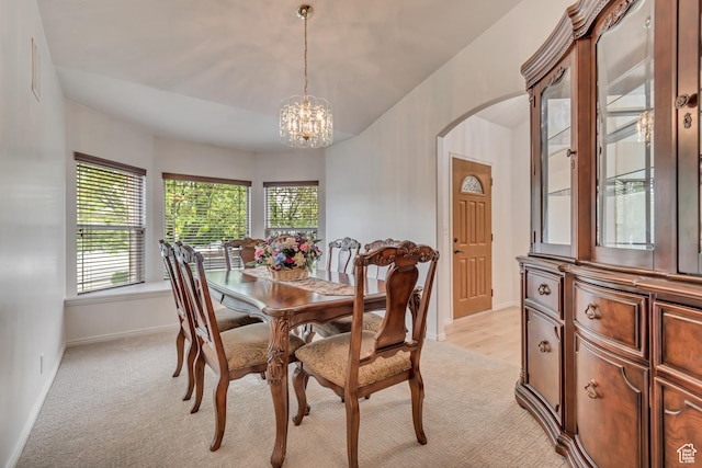 12159 S Swensen Cir, Riverton, UT 84096 - dining space with arched walkways, a chandelier, light carpet, and baseboards