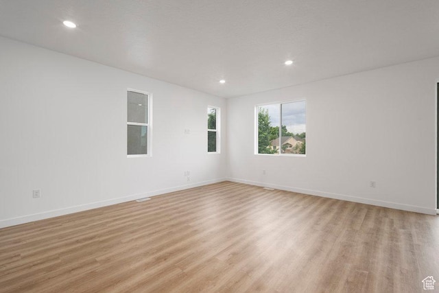 spare room featuring light wood-style flooring, baseboards, and recessed lighting