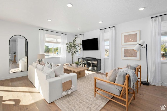 living room featuring healthy amount of natural light, wood finished floors, recessed lighting, and baseboards