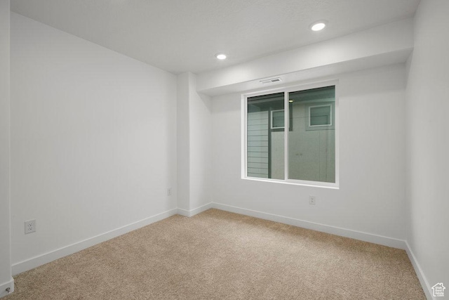 spare room featuring carpet, recessed lighting, and baseboards