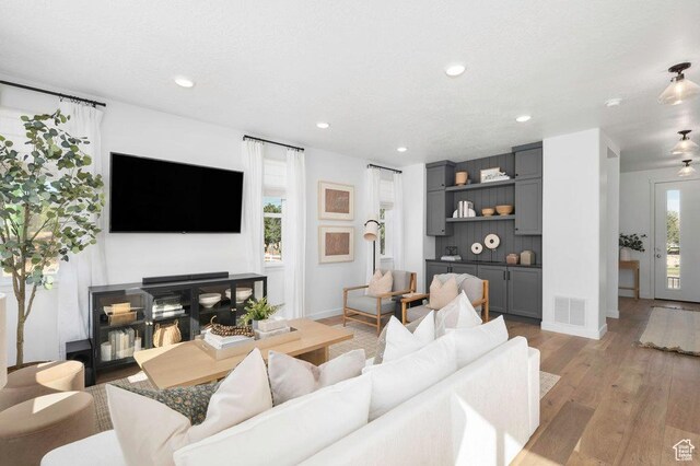 living area with light wood-style flooring, recessed lighting, and baseboards