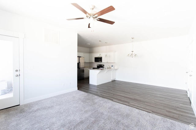 1454 N 3830 W Unit D201, Lehi, UT 84043 - unfurnished living room featuring visible vents, dark wood finished floors, baseboards, ceiling fan with notable chandelier, and dark carpet