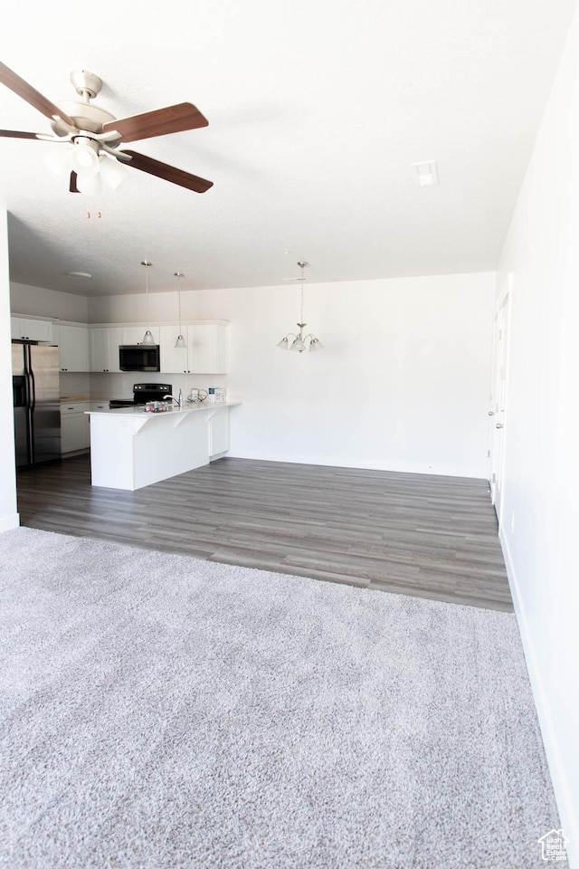 1454 N 3830 W Unit D201, Lehi, UT 84043 - unfurnished living room with baseboards, dark wood-style floors, ceiling fan with notable chandelier, and dark colored carpet