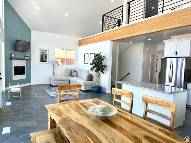 1610 N Mackinaw Way, Garden City, UT 84028 - dining area with a fireplace, dark wood finished floors, baseboards, a towering ceiling, and recessed lighting