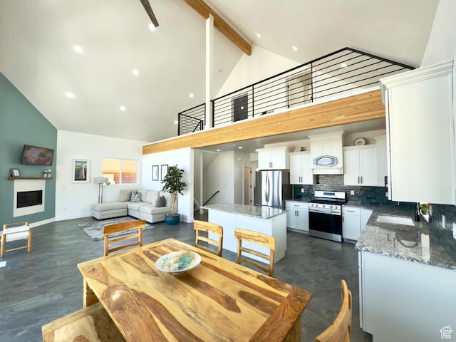 1610 N Mackinaw Way, Garden City, UT 84028 - dining room with stairs, high vaulted ceiling, beam ceiling, a fireplace, and baseboards