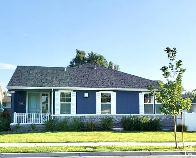 rear view of house featuring a yard, a porch, and stucco siding