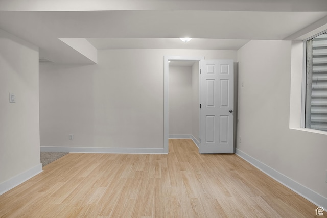 unfurnished room with light wood-style flooring and baseboards