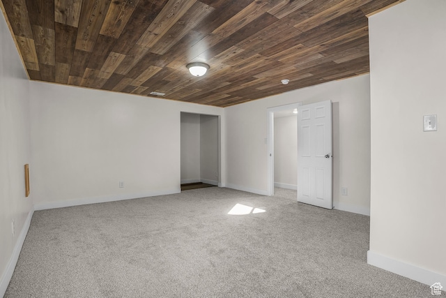 carpeted empty room with wood ceiling and baseboards