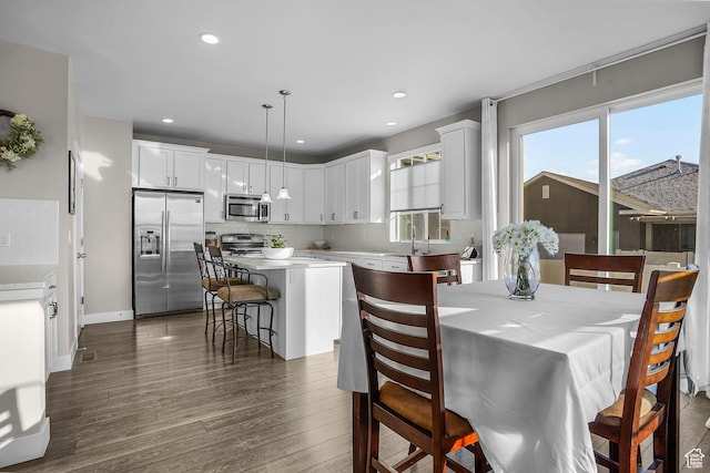 dining room featuring baseboards, dark wood-type flooring, and recessed lighting