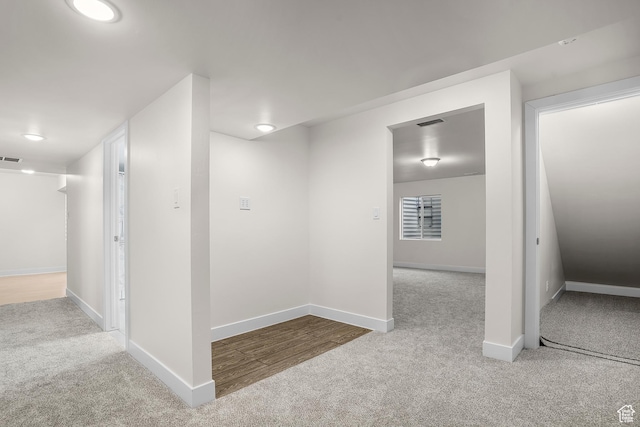 interior space featuring light colored carpet, visible vents, and baseboards