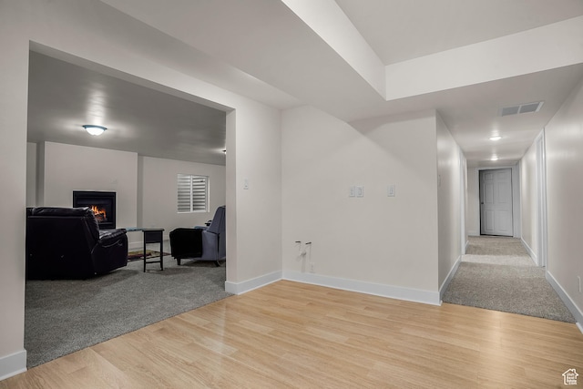 corridor featuring light wood-style floors, baseboards, and visible vents