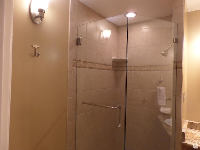 bathroom featuring a shower with door and vanity