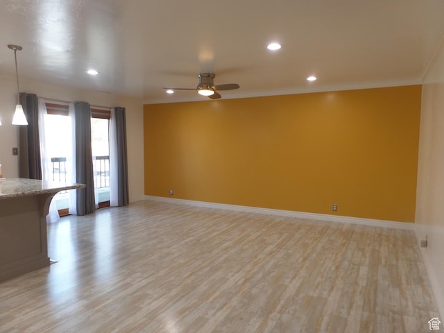 unfurnished living room with crown molding, ceiling fan, and light hardwood / wood-style floors