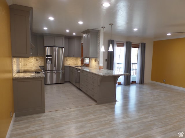 kitchen featuring sink, decorative light fixtures, appliances with stainless steel finishes, kitchen peninsula, and gray cabinets