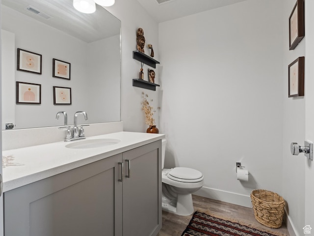 bathroom with vanity, wood-type flooring, and toilet