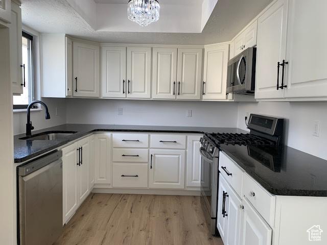 kitchen featuring appliances with stainless steel finishes, sink, and white cabinets