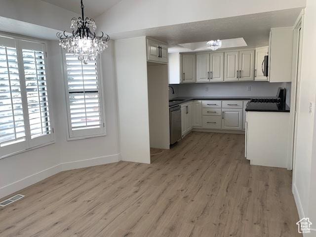 kitchen featuring a notable chandelier, a wealth of natural light, vaulted ceiling, and stainless steel dishwasher