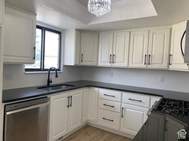 kitchen with white cabinetry, dishwasher, and sink