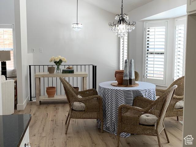 1107 E Brigadoon Ct, Holladay, UT 84117 - dining space featuring healthy amount of natural light, a chandelier, vaulted ceiling, and light wood-style flooring