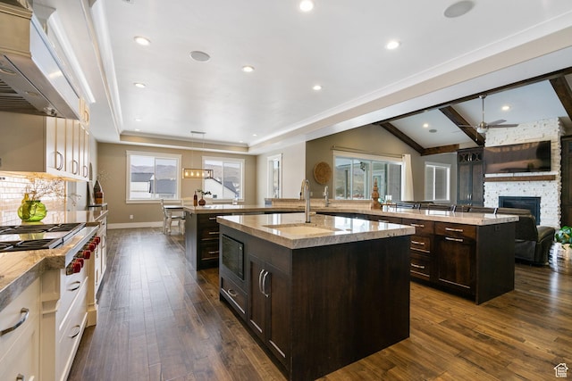 1595 E Duggan Dr, Eagle Mountain, UT 84005 - kitchen with a kitchen island with sink, custom exhaust hood, and dark brown cabinetry