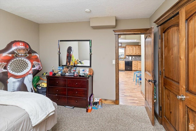 bedroom with light colored carpet and a textured ceiling