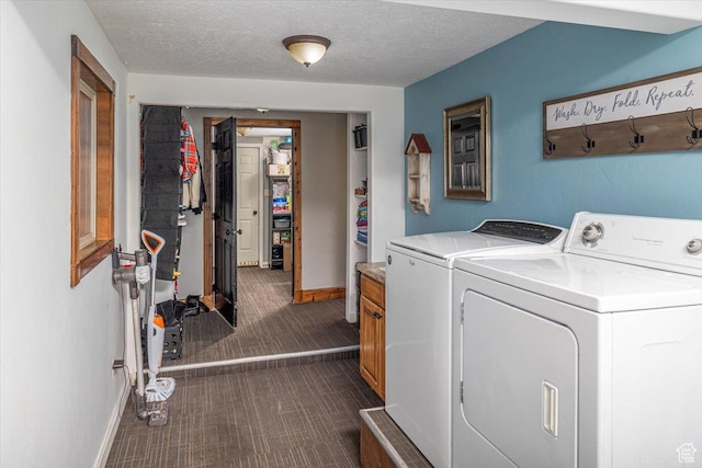 laundry area with dark carpet, washing machine and dryer, cabinets, and a textured ceiling