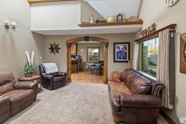 living room with a towering ceiling and carpet