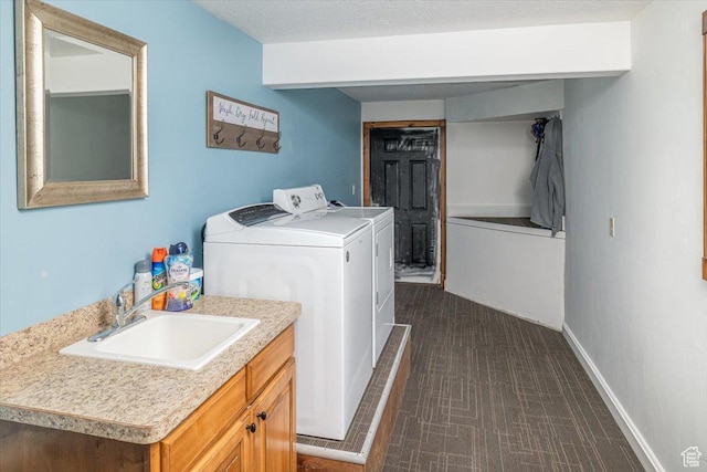 washroom featuring sink, independent washer and dryer, and a textured ceiling