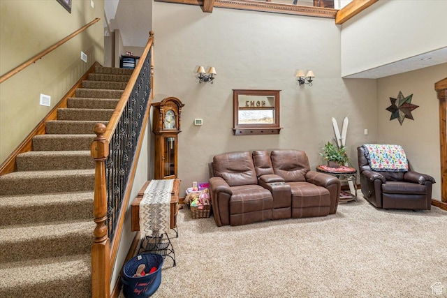 carpeted living room featuring a towering ceiling