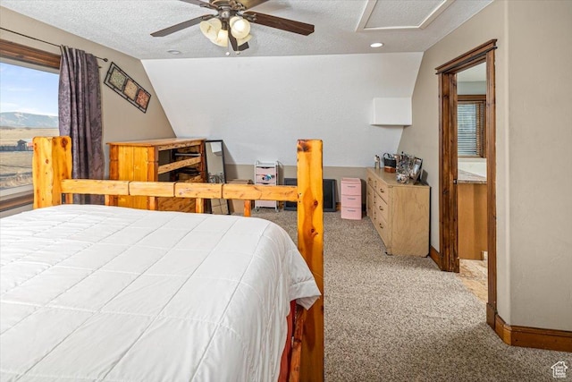 carpeted bedroom featuring ceiling fan, vaulted ceiling, and a textured ceiling
