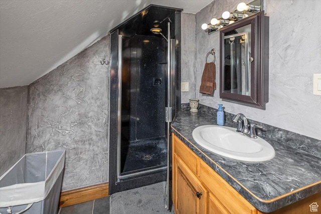 bathroom featuring vanity, vaulted ceiling, tile patterned floors, and a textured ceiling
