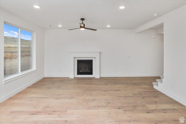 unfurnished living room featuring ceiling fan and light hardwood / wood-style floors