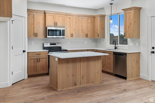 kitchen with sink, tasteful backsplash, decorative light fixtures, light wood-type flooring, and appliances with stainless steel finishes