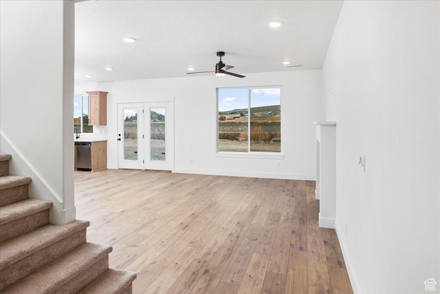 unfurnished living room with ceiling fan and light hardwood / wood-style floors