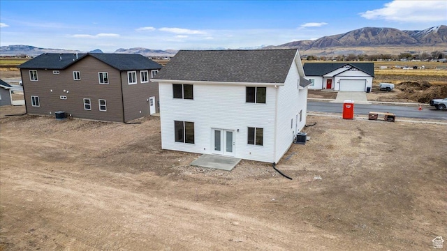 rear view of house with a mountain view and central AC unit