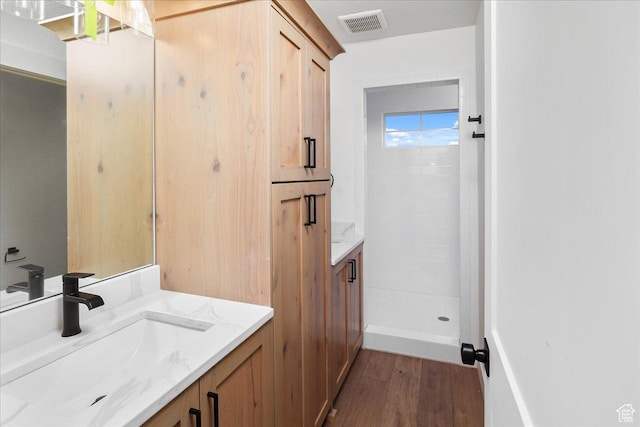 bathroom featuring a shower, hardwood / wood-style floors, and vanity