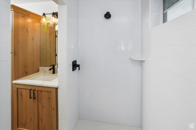 bathroom with vanity and a tile shower