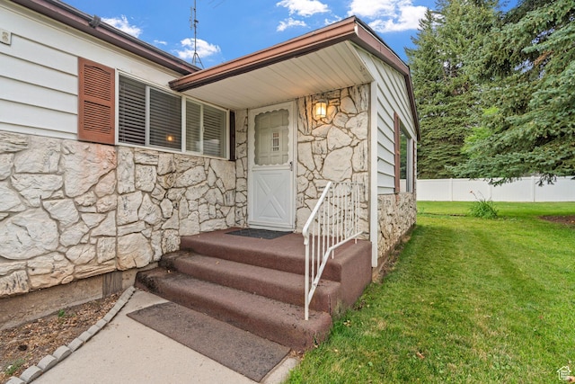 view of exterior entry featuring a yard