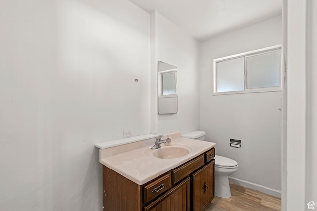 bathroom featuring vanity, wood-type flooring, and toilet