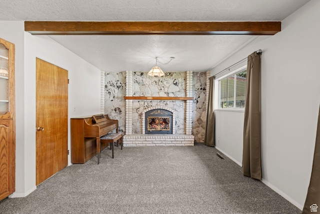 unfurnished living room featuring beamed ceiling, a fireplace, carpet flooring, and a textured ceiling