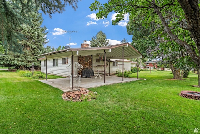 back of house with a patio area and a lawn