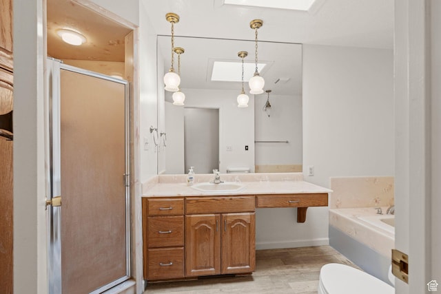 full bathroom with separate shower and tub, wood-type flooring, a skylight, and vanity