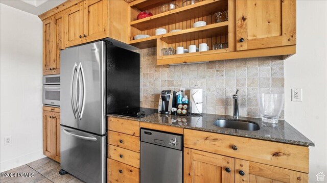 1456 Newpark Blvd Unit 215, Park City, UT 84098 - kitchen with sink, light tile patterned floors, appliances with stainless steel finishes, tasteful backsplash, and dark stone counters