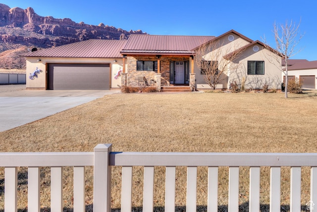 4230 S Beeman Rd, Moab, UT 84532 - view of front facade featuring a garage, a mountain view, and a front yard