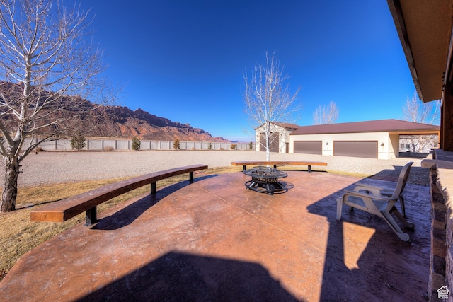 4230 S Beeman Rd, Moab, UT 84532 - view of patio with a mountain view, a garage, and an outdoor fire pit