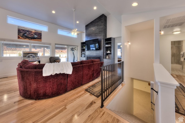 4230 S Beeman Rd, Moab, UT 84532 - living room featuring a fireplace, light hardwood / wood-style floors, ceiling fan, and a high ceiling