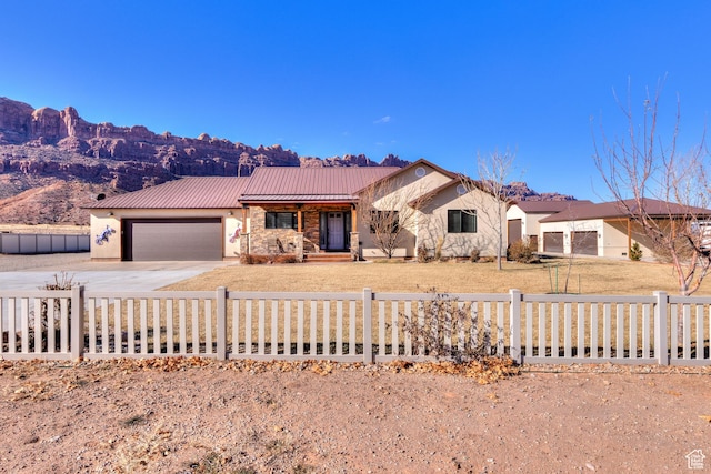 4230 S Beeman Rd, Moab, UT 84532 - view of front of house featuring a garage, a mountain view, and a front lawn